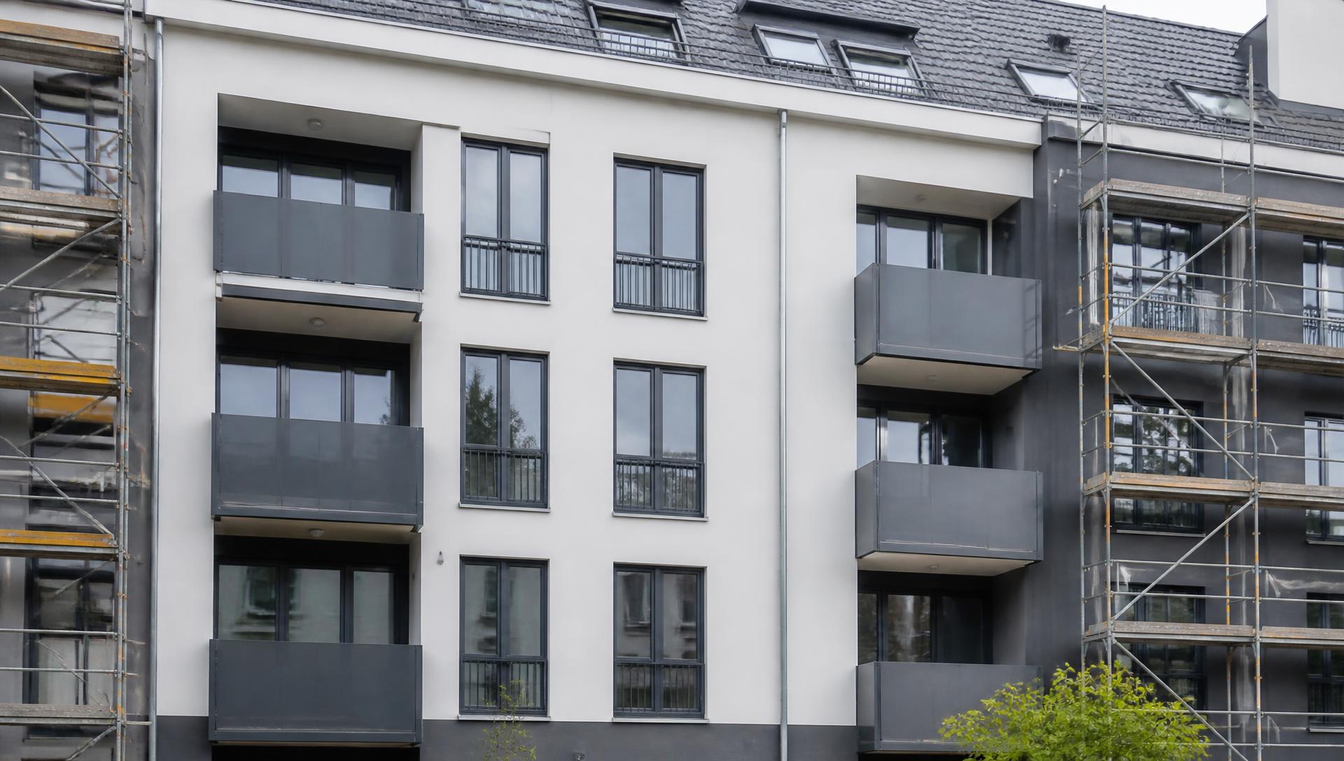Frisch sanierte Fassade eines Mehrfamilienhauses mit Gerüst